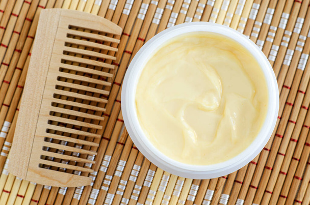 Yellow vanilla face mask (banana cream, shea butter facial mask, body butter) in the small white jar. Natural skin and hair care concept. Top view, copy space. - Foto, Bild