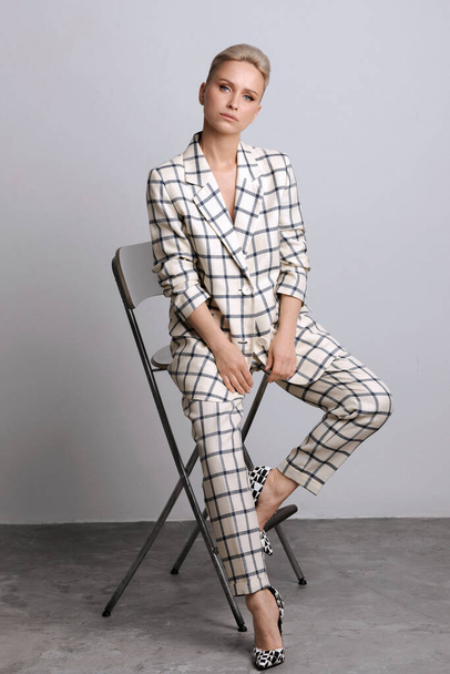 Elegant ant charismatic short blond haired and natural makeup businesswomen wearing oversized linen suit with blue stripes posing isolated in studi - Foto, Imagem