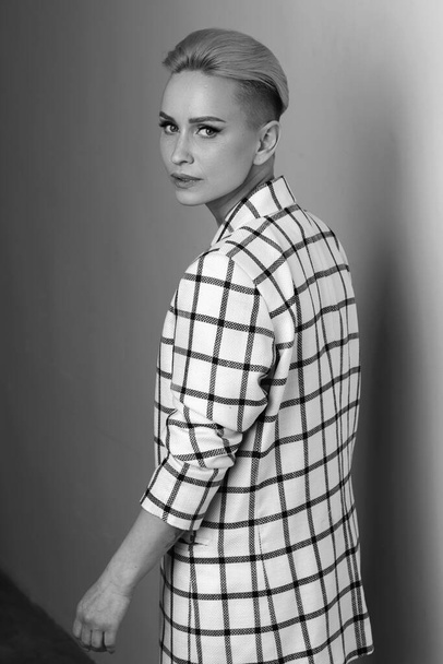 Elegant ant charismatic blond and short haired women with beautiful wide smile wearing oversized linen suit posing isolated in studio. Black and white versio - Foto, imagen