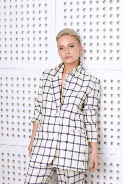 Elegant ant charismatic short blond haired and natural makeup businesswomen wearing oversized linen suit with blue stripes posing isolated in studi - Foto, immagini