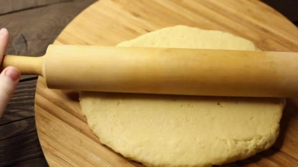 woman prepares dough for baking, rolls out on a wooden board, hands close-up, process of cooking - Footage, Video