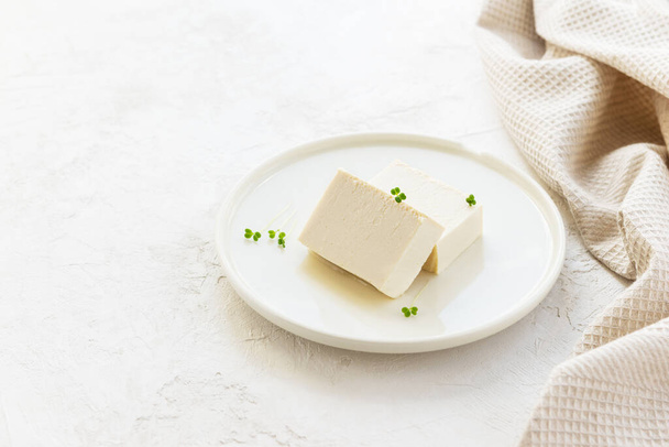 Tofu cheese with micro greens on a plate. Horizontal orientation, copy space. Selective focus.  - Photo, Image
