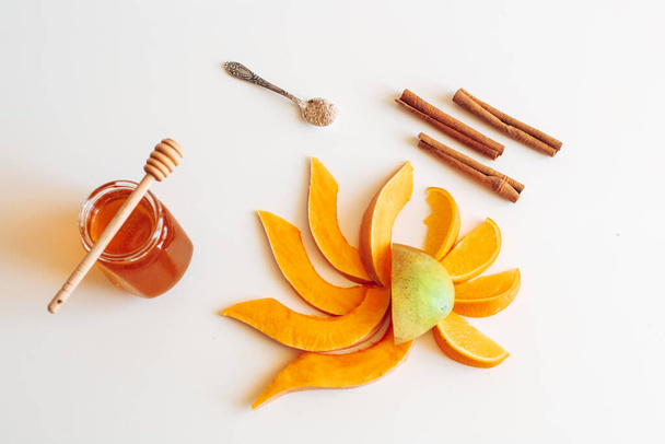 μάνγκο, κολοκύθα, μέλι, κανέλα, πορτοκάλι στο τραπέζι - Φωτογραφία, εικόνα
