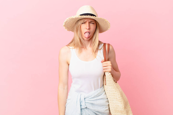 young blonde woman feeling disgusted and irritated and tongue out. summer concept - Foto, afbeelding
