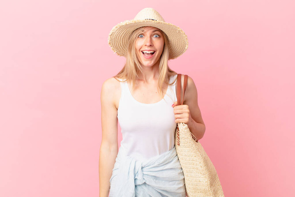 young blonde woman looking happy and pleasantly surprised. summer concept - Foto, afbeelding