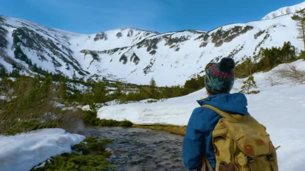 Молодая женщина с рюкзаком путешествует по горам - Кадры, видео
