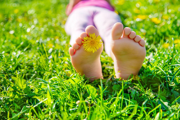 Dětské nohy na trávě. Selektivní soustředění. Kluk. - Fotografie, Obrázek