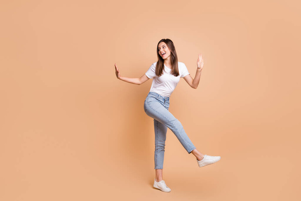 Full length body size photo of dancing at party girl smiling looking blank space isolated on pastel beige color background - Photo, image