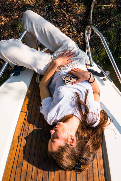 Стокгольм, Швеція Жінка лягає на палубу маленького човна, а ноги звисають над краєм.. - Фото, зображення