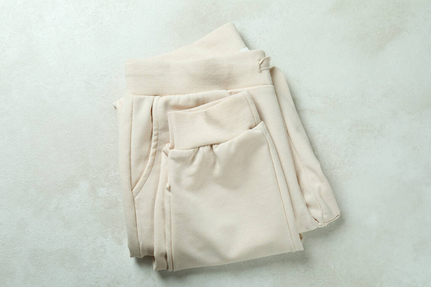 Folded sweatpants on white textured background, top view - Foto, imagen