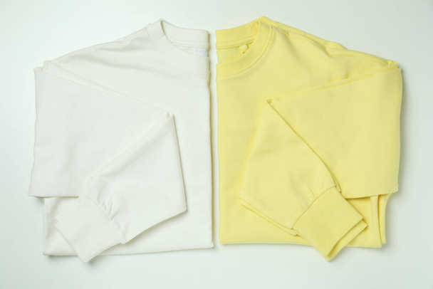 White and yellow sweatshirts on white background - Foto, imagen