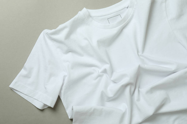 Blank white t-shirt on gray background, close up - Fotografie, Obrázek