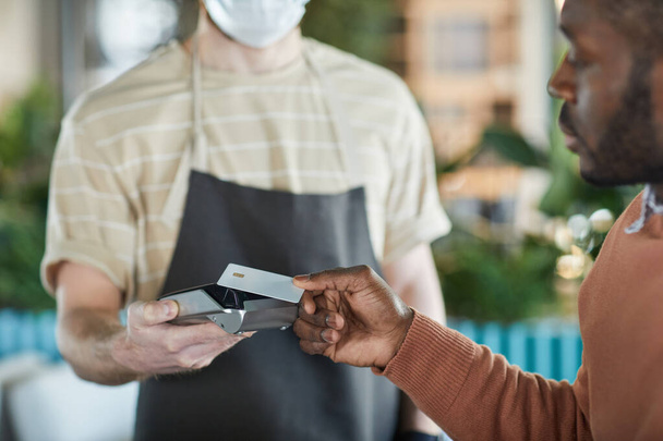 Blisko Afroamerykanin płaci kartą kredytową makiety w kawiarni lub restauracji, przestrzeń do kopiowania - Zdjęcie, obraz