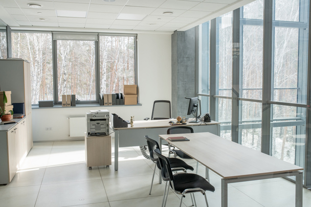 Malá kancelář s panoramatickou zdí v business centru: stůl s počítačem a skenerem, dlouhý stůl pro jednání - Fotografie, Obrázek