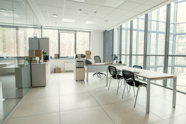 Sala de escritório moderna com janela panorâmica mobilada por mesas e cadeiras, escritório vazio - Foto, Imagem