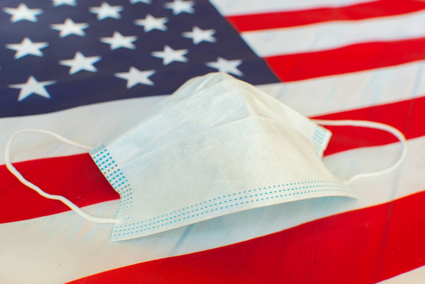 Medical mask on background with American flag. 4th of July Independence Day USA safety. - Fotografie, Obrázek