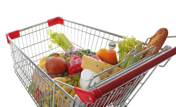 Shopping cart with fresh groceries on white background - Фото, зображення