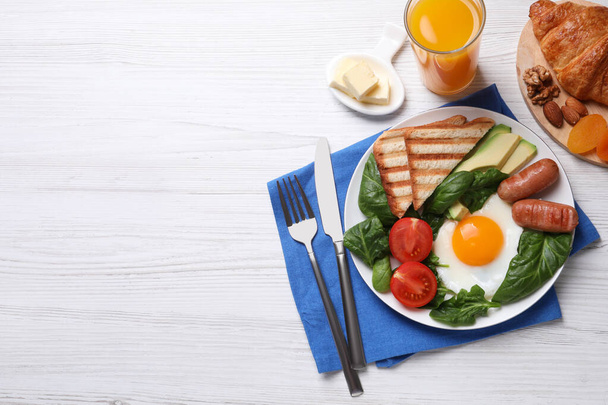 Delicious breakfast with fried egg served on white wooden table, flat lay. Space for text - Foto, Bild