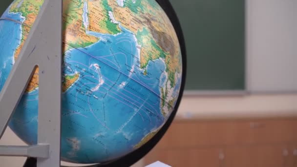 Schulkonzept, Globus und Lineal auf dem Hintergrund der Schultafel im Klassenzimmer. Schul- oder Hochschulatmosphäre - Filmmaterial, Video