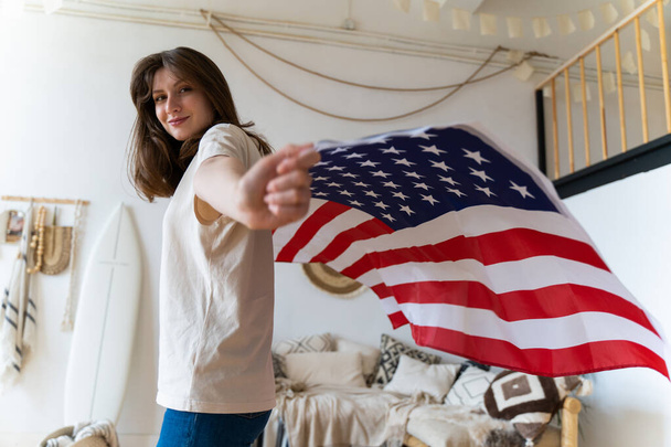 US. Independence and immigration. Beautiful young woman poses with Americas national flag - Photo, Image