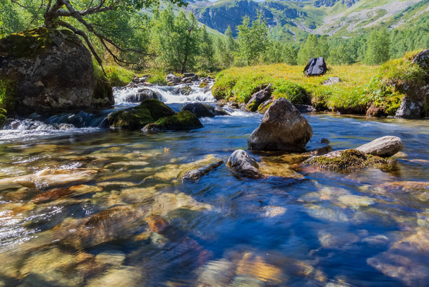 een Fast mountain river voert zijn stroom door een rotsachtige bedding - Foto, afbeelding