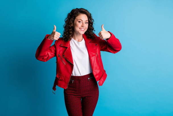 Photo of nice optimistic girl show approval sign wear red jacket pants isolated on blue color background - Фото, изображение