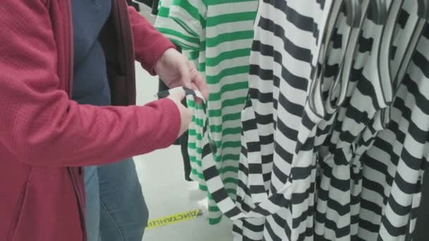 Pregnant woman chooses a loose dress in black and white stripes. Hands close up - Footage, Video