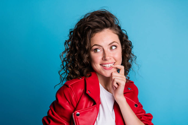 Photo of adorable curly hairstyle cheerful person biting finger nail look empty space isolated on blue color background - Zdjęcie, obraz