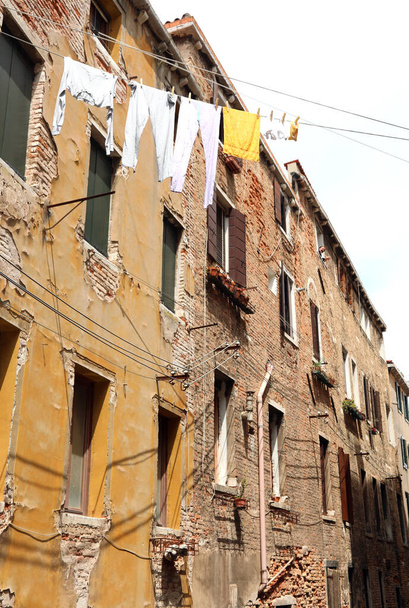 Kleider hängen zum Trocknen in einer italienischen Stadt mit antiken Häusern - Foto, Bild