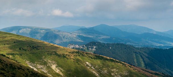 Вид с холма Крижна в горах Велка Фатра в Словакии с многочисленными порывами ветра и преимущественно облачным небом - Фото, изображение