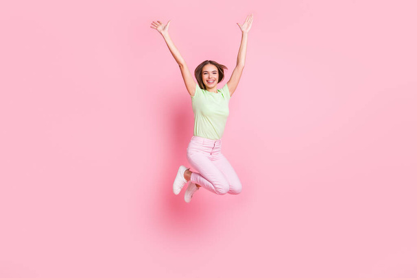 Full body portrait of astonished pretty person jump raise arms palms isolated on pink color background - Foto, Bild