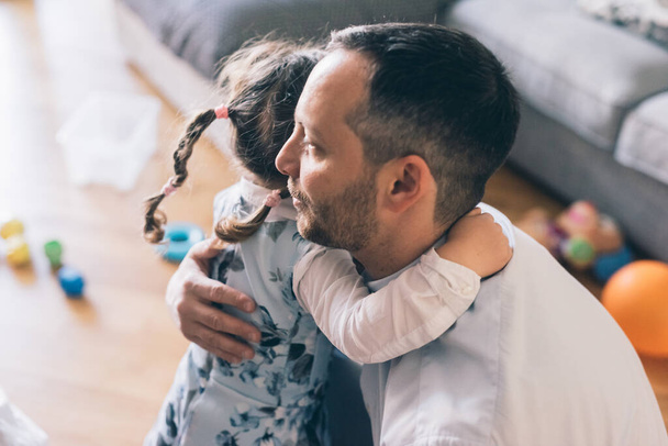 Papa umarmt Tochter zu Hause  - Foto, Bild