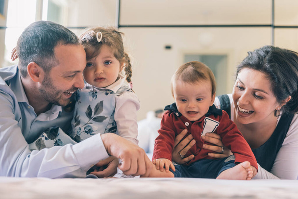 Onnellinen perhe kahden lapsen kanssa kotona leikkimässä yhdessä - Valokuva, kuva