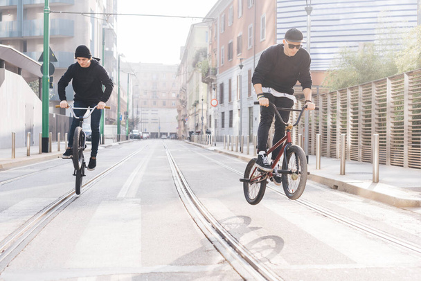 Zwei junge Teenager springen und tricksen mit dem BMX-Rad - Foto, Bild