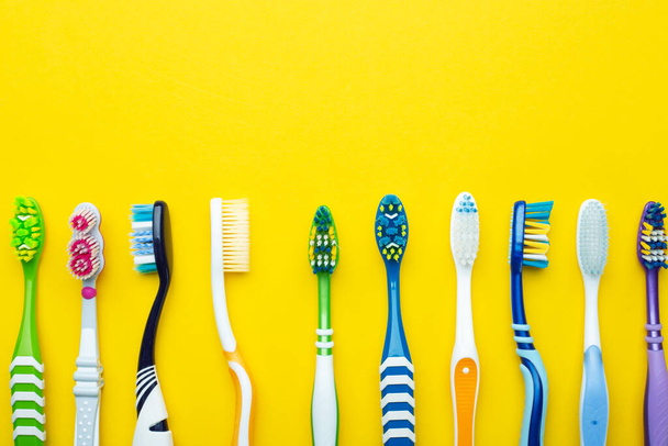 Toothbrushes on a yellow background. Health care, dental hygiene. Space for text. Top view. - Фото, зображення