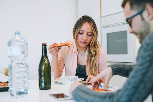 Nuori pari yhdessä kotona ruokailu pizza - Valokuva, kuva