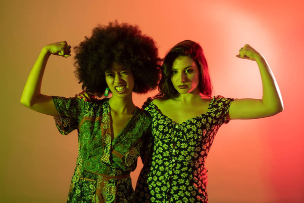 Young multiethnic women indoor studio showing biceps confident and proud - Photo, Image