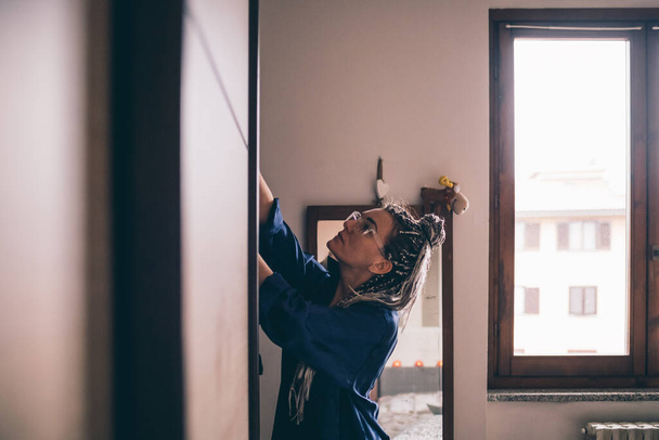 Felnőtt nő beltéri otthon decluttering szekrény kiválasztása  - Fotó, kép