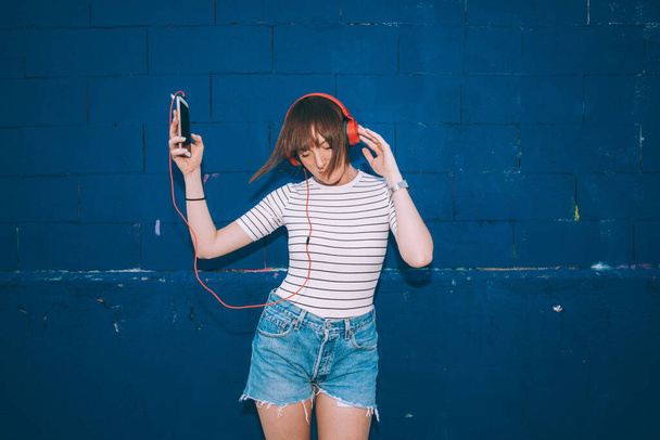 Νεαρή γυναίκα σε εξωτερικούς χώρους χορό ακούγοντας μουσική ακουστικά smartphone - Φωτογραφία, εικόνα