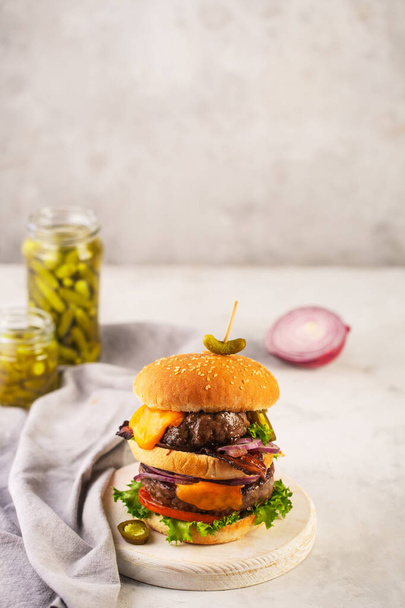 Home made burger with two cutlets and bacon on a concrete gray background - Foto, immagini