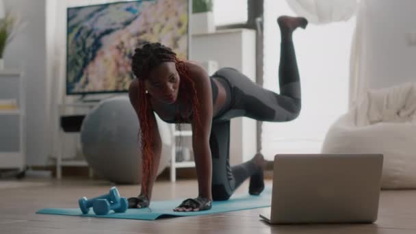 Черный спорт женщина делает утром фитнес рутины смотреть фитнес видео - Кадры, видео