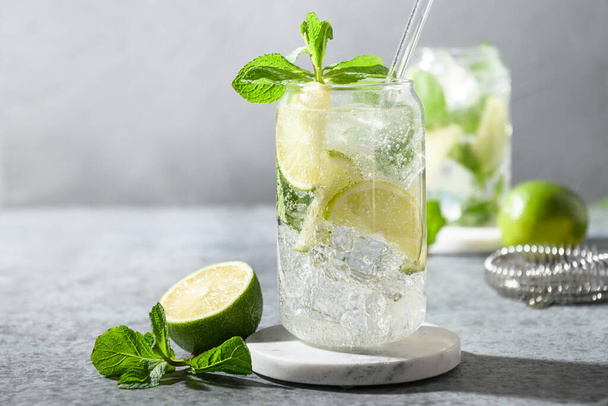 Freshness mojito with lime, mint, ice cube on gray background. Close up. Summer popular beverage. - Foto, Imagen