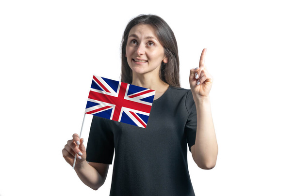 Glückliche junge weiße Frau mit der Flagge Großbritanniens und zeigt vereinzelt mit dem Daumen nach oben auf weißem Hintergrund. - Foto, Bild