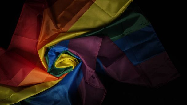 LGBTQの誇りフラグ。レズビアンゲイ双方向性転換クィア.同性愛者の誇りゲイの手でレインボーフラッグ。黒の背景。自由、平和、平等、愛の象徴です。LGBTQの概念.  - 写真・画像