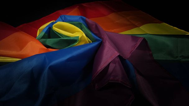 LGBTQ ylpeys lippu. Lesbo homo bi seksuaalinen transsukupuolinen homo. Homoseksuaalinen ylpeys Sateenkaari lippu homo kädessä. Musta tausta. Edustaa vapauden, rauhan, tasa-arvon ja rakkauden symbolia. LGBTQ-käsite.  - Valokuva, kuva