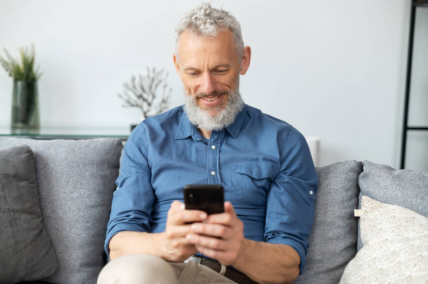 Middle aged bearded man using smartphone - Foto, Imagen
