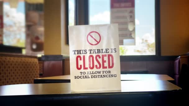 Робітник розміщує і видаляє "закритий стіл" знак в ресторані швидкого харчування. Таблиці закриття були поширеною практикою, щоб зупинити поширення COVID-19 в 2020 і 2021 роках.. - Кадри, відео