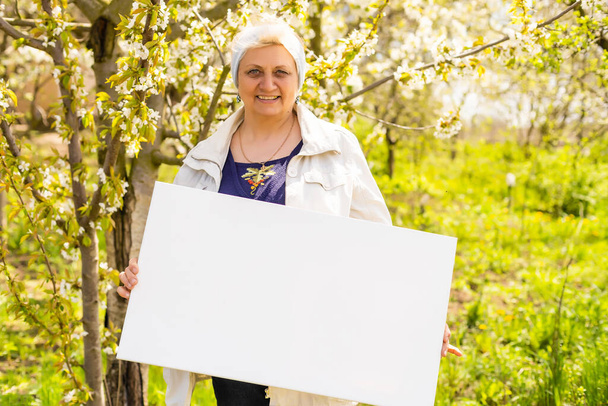 starší žena drží foto plátno - Fotografie, Obrázek