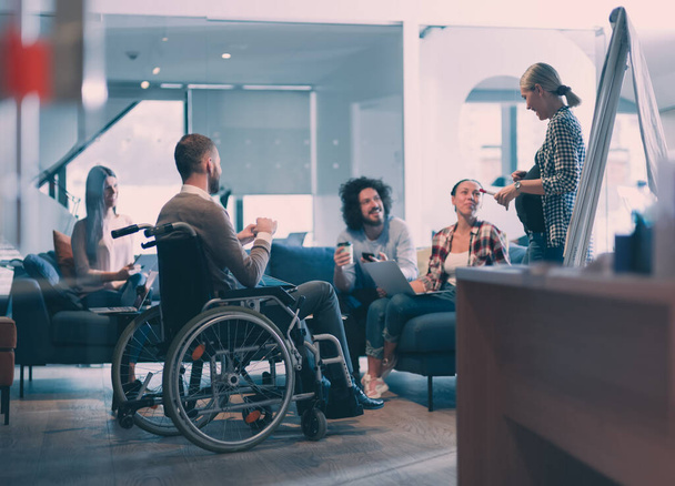 Pregnant Businesswoman Leads Creative Meeting Of Diverse Business Team In Modern Coworking Open Space Office, Disabled coworker in wheelchair attending training  - Foto, afbeelding