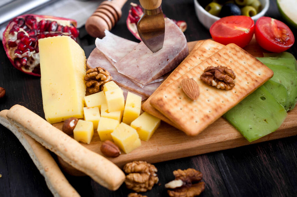 Assorted homemade pieces cheese with honey, fruits, cookies and nuts on table.  Fresh dairy product, healthy organic food. Delicious appetizer. - Foto, Imagem
